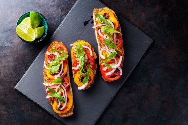 Karanlık bir arka planda İspanyol tapaları. Domates, soğan, yeşillik ve zeytinli vejetaryen tapas. Tahta tahtada sağlıklı sandviçler. Üst Manzara. Boşluğu kopyala