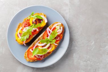 Betondaki İspanyol tapaları. Taze domates, yeşillik ve zeytinli Gri tabakta vejetaryen sandviçler. Üst Manzara. Boşluğu kopyala