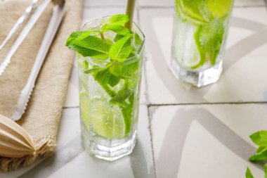 Mojito ve bar aksesuarları fayansta. İki bardak naneli ve limonlu mojito kokteyli. Bambu pipetli yaz kokteyli.
