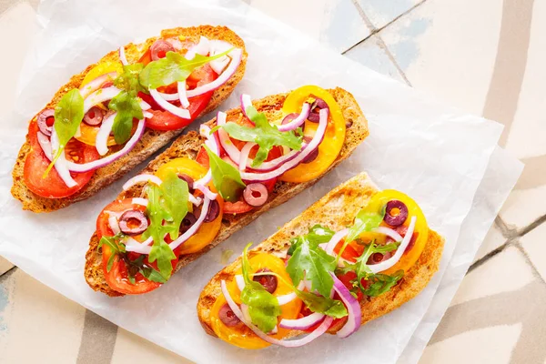 Kağıt üzerinde sağlıklı vejetaryen tostları. Taze domates, yeşillik ve zeytinli vejetaryen sandviçler. Ta ki vejetaryen İspanyol tapas yiyene kadar. Üst görünüm