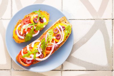 Vegetarian tapas on tile. Bruschetta with fresh tomato, greens and olives. Vegetarian open sandwiches on gray plate. Top view. Copy space