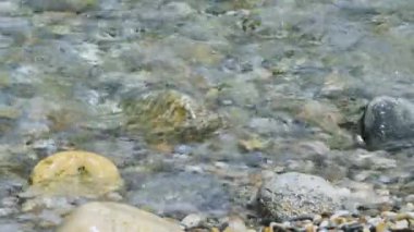 Waves on pebble beach. Clear water waves flowing over pebble beach shore