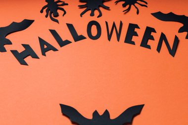 Turuncu arka planda yarasalar ve örümcekler olan Cadılar Bayramı korku konsepti. Cadılar Bayramı yaratıcı geçmişi. Ürkütücü fikir.