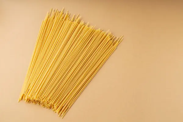 Raw Spaghetti Pasta Beige Background Scattered Yellow Long Spaghetti Copy — Stock Photo, Image