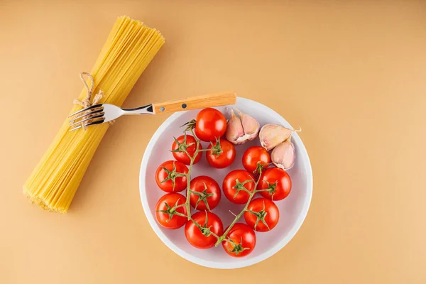 Spaghetti Pasta Con Pomodori Aglio Fondo Beige Pasta Cruda Verdure — Foto Stock