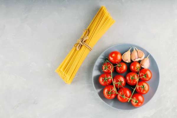 Spaghetti Pasta Con Pomodori Aglio Sfondo Grigio Mazzo Spaghetti Legati — Foto Stock