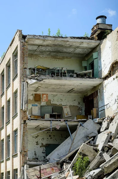 School building disintegrating in Prypiat, epicenter of the Chernobyl nuclear disaster in Ukraine. Collapsed side wall making the inner rooms visible. High quality photo