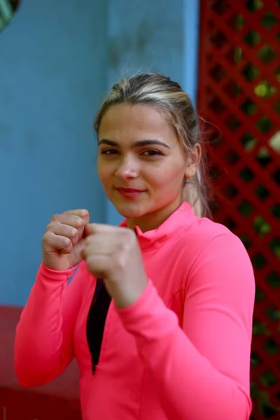 Isolated portrait of athletic woman slim athletic girl in training clothes looking at camera. Vertical concept photo of sport, boxing, victory, rivalry.