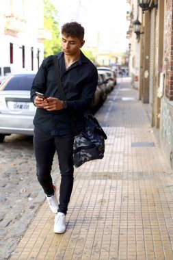 Akıllı telefon kullanan genç bir şehirli profesyonel. SMS iletisi gönderiliyor