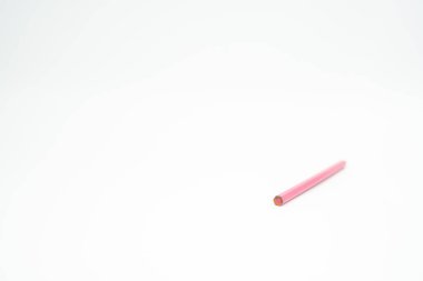 Beyaz zemin üzerinde pembe ahşap kalem, ucu odaklı.