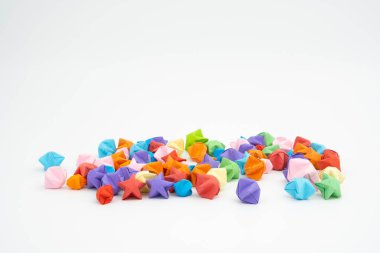 Çeşitli renklerde dağılmış küçük origami yıldızları