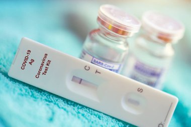 Coronavirus için Covid-19 Hızlı Antijen Test kiti ve Covid Aşı Dozu Şişesi.