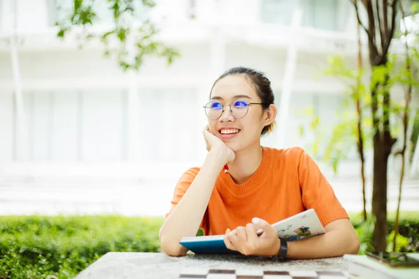 Aziatische Universiteit Tiener Meisje Glimlachen Zitten Outdoor Lezen Boek — Stockfoto