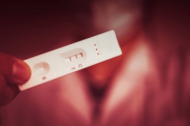 Covid veya Hamilelik için yapılan antijen testi tespit edilen veya pozitif sonuç veren kırmızı ton için test konumunda görünür bir çizgi gösteriyor.