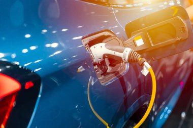 EV araba şarj oluyor. Modern elektrikli araba gelecekteki ulaşım konsepti için yeşil enerji ve eko enerjisi yüklüyor.
