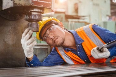 Mühendislik personeli kurulum kontrol durumu. Metal endüstrisi işyerinde güvenlik için CNC makinesinin matkap başı..