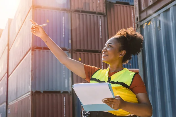 African teen black woman staff worker work check stock inventory in port cargo shipping portait happy smile