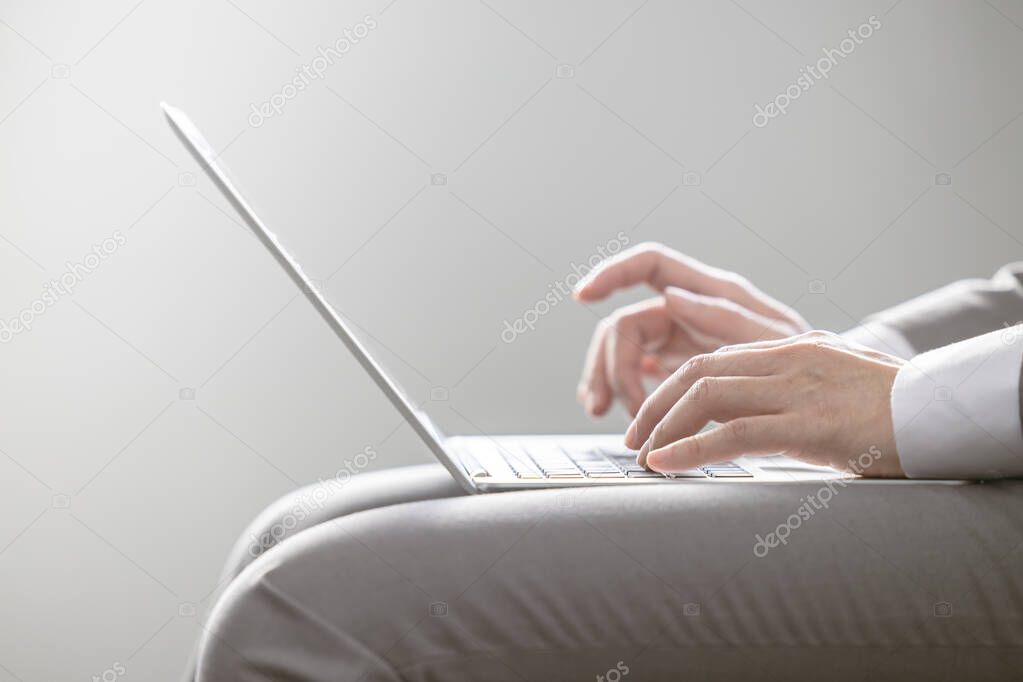 closeup businessman hand typing on light thin laptop computer keyboard for business working communication wireless