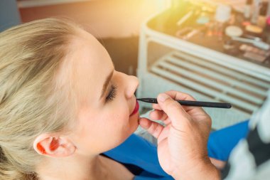 Güzel beyaz kadınlar güzellik için makyaj modeli olurlar. boya dudak parlatıcısı çiziyor.