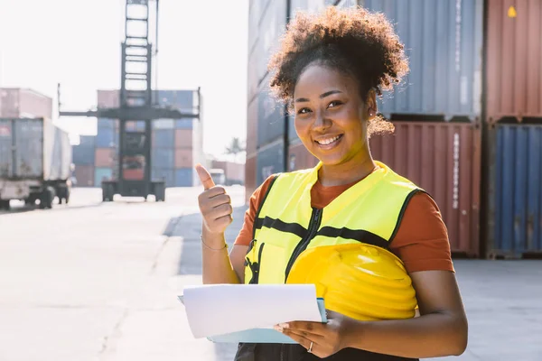 在港口货运业工作的快乐的非洲女工站在那里微笑 — 图库照片