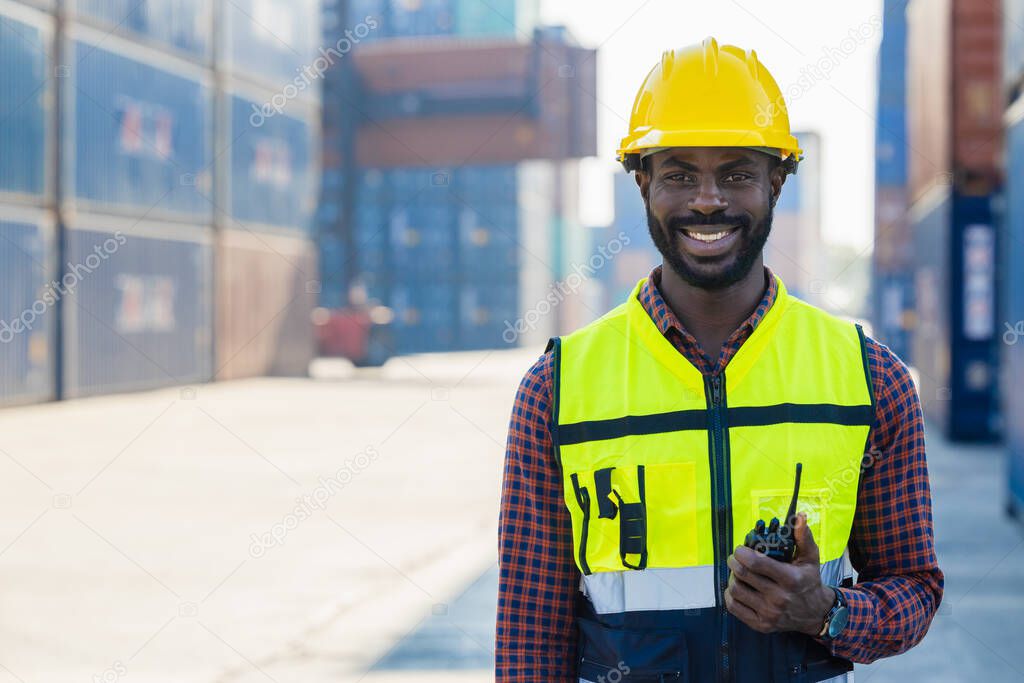 black worker African working engineer foreman radio control in port cargo shipping customs container yard
