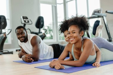 Çocuklu siyahi aile ebeveynleri spor kulübünde birlikte sağlık hizmetleri için egzersiz yapıyorlar..