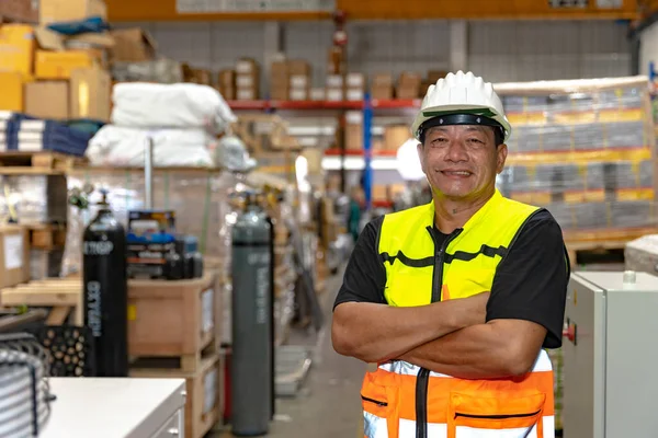 Southeast asia staff engineer worker man portrait confident happy smiling arm crossed in factory warehouse.