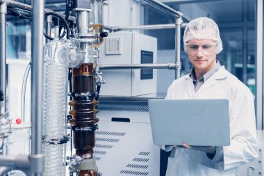 Medicine factory scientist worker with Cannabis CBD oil extraction machine. Hemp oil extraction Thin Film Distillation Laboratory Plants Process.
