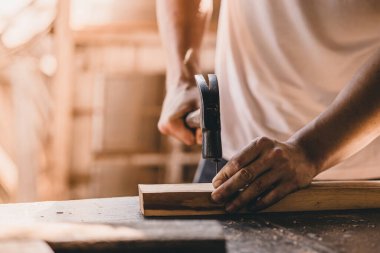 builder wood worker hammer on nails into the wood. construction build renovate and danger at work concept.