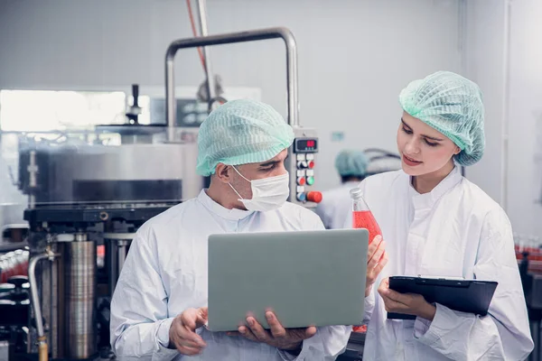 Food and Drink factory worker working together with hygiene monitor control mix ingredients machine with laptop computer