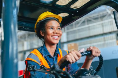 Forklift sürücüsünde çalışan kadın işçiler mutlu bir gülümseme ile fabrika lojistik nakliye deposunda çalışmanın keyfini çıkarıyorlar..