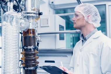 medicine factory scientist worker with Cannabis CBD oil extraction machine. Hemp oil extraction Thin Film Distillation Laboratory Plants Process.
