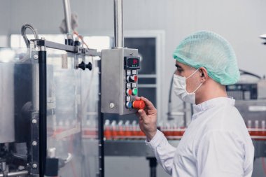 Yiyecek ve içecek fabrikası mühendisi üretim bandında makine çalıştırıyor. içecek ürünleri endüstrisi.