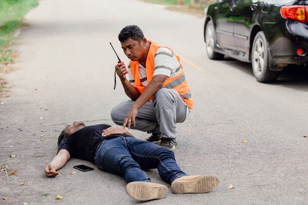man accident lay down unconscious on the road hit by car during playing phone emergency team staff radio for help