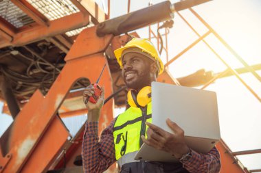 Mutlu işçi ustabaşı kargo taşımacılığı endüstrisinde yükleme kontrolünde çalışıyor. Mühendis kontruction sitesinde çalışıyor.