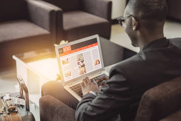 business man reading news update website in laptop during waiting for travel in airport lounge