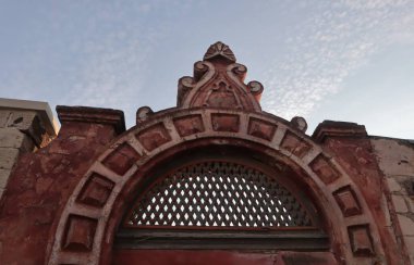 Mavi arka planda kafesi olan eski bir binanın tuğla kemeri..