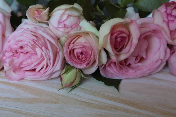 Een Mooi Boeket Roze Rozen Ligt Een Licht Houten Oppervlak — Stockfoto