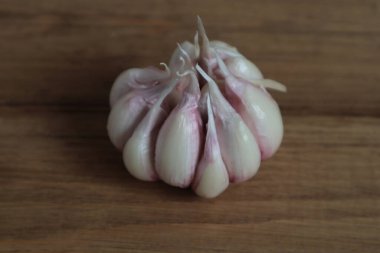 Sarımsak başı ahşap bir yüzeyde yatıyor..