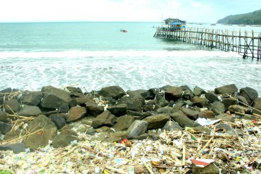 Plaj, Pangandaran Sahili, Batı Java, Endonezya 'nın küçük iskelesindeki plastik atıklarla kirlenmiş. .
