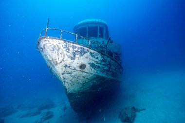 Eski paslı gemi enkazı mavi suyun arka planında
