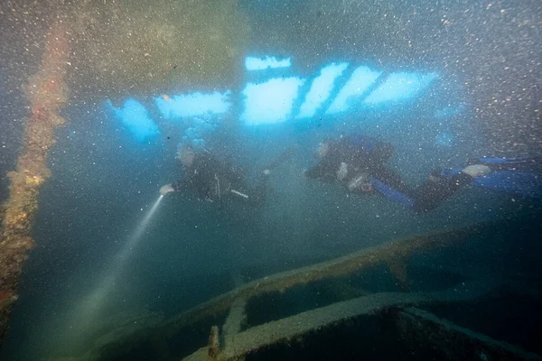 Eski paslı gemi enkazı mavi suyun arka planında