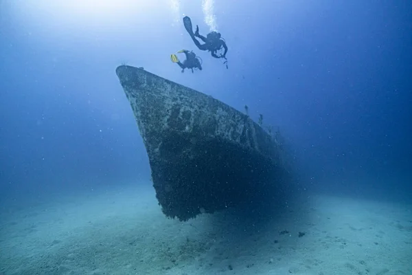 Eski paslı gemi enkazı mavi suyun arka planında