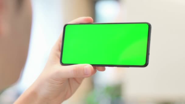Jeune homme regardant Smartphone avec écran Chroma vert — Video