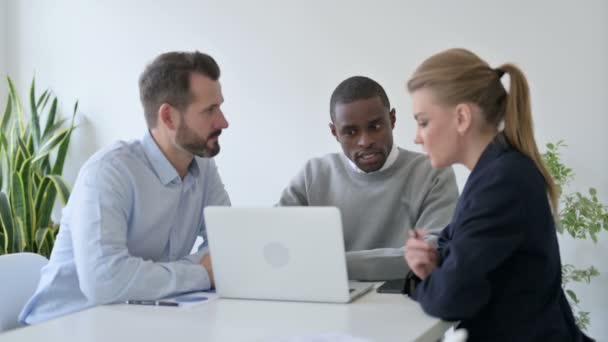 Gente de negocios masculina y femenina discutiendo mientras usa el ordenador portátil en la oficina — Vídeos de Stock