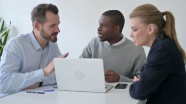 Ofiste dizüstü bilgisayar kullanırken Erkek ve Kadın İş Adamları Tartışıyor 