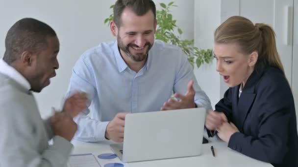 Веселые деловые люди празднуют успех во время использования ноутбука в офисе — стоковое видео