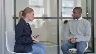 Tabletli genç iş kadını Afrikalı iş adamıyla röportaj yapıyor