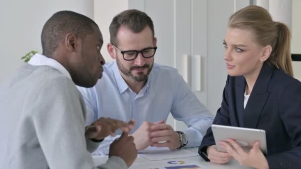 Серьезные мужские и женские деловые люди разговаривают в офисе — стоковое видео