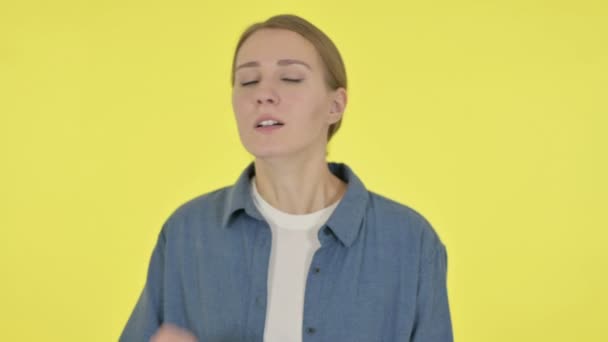 Mladá žena kašlání na žlutém pozadí — Stock video